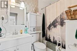 Bathroom with vanity, toilet, backsplash, and shower / bathtub combination with curtain - 