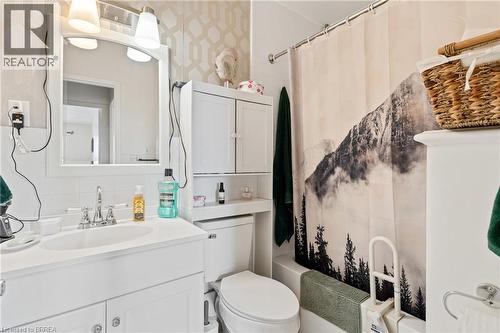 Bathroom with vanity, toilet, backsplash, and shower / bathtub combination with curtain - 485 Thorold Road Unit# 323, Welland, ON - Indoor Photo Showing Bathroom
