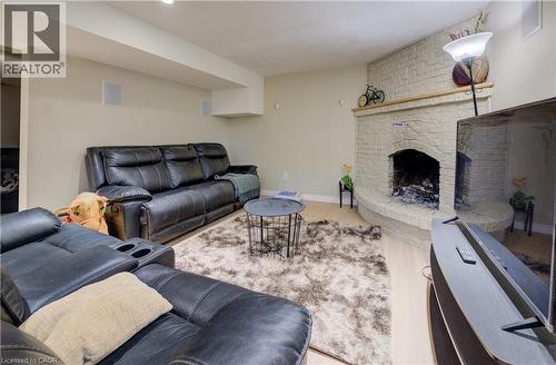 Living room with a brick fireplace and wood finished floors - 31 Bonfair Court, Kitchener, ON - Indoor Photo Showing Living Room With Fireplace