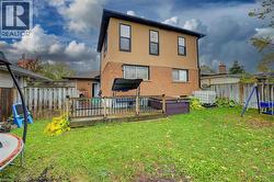 Back of house with a deck, a fenced backyard, stucco siding, brick siding, and a trampoline - 