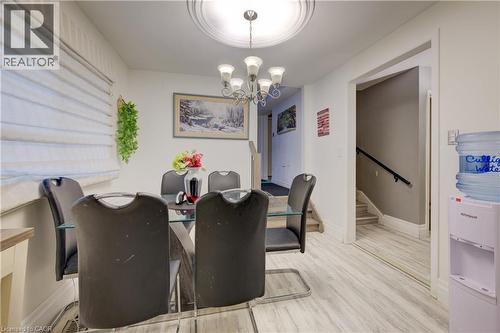 Dining room with light wood-type flooring, a chandelier, and stairs - 31 Bonfair Court, Kitchener, ON - Indoor