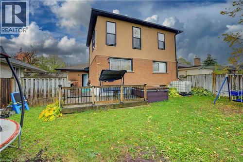 Back of house with a deck, a fenced backyard, stucco siding, brick siding, and a trampoline - 31 Bonfair Court, Kitchener, ON - Outdoor