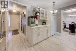 Kitchen with glass insert cabinets, open shelves, freestanding refrigerator, and light wood-type flooring - 