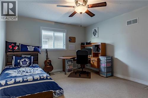 Bedroom with light colored carpet, a desk, a ceiling fan, and a textured ceiling - 28 Springbreeze Heights, Hamilton, ON - Indoor Photo Showing Bedroom