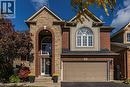 View of front of house with a garage, stone siding, driveway, and brick siding - 28 Springbreeze Heights, Hamilton, ON  - Outdoor With Facade 