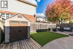Fenced backyard with a wooden deck, an outdoor hangout area, a shed, and a patio area - 