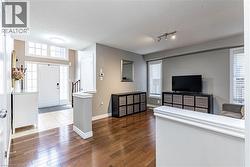 Living room featuring a textured ceiling, plenty of natural light, dark wood finished floors, and rail lighting - 