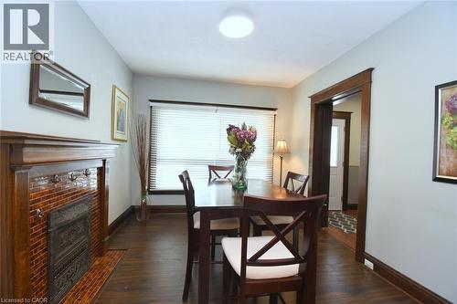 Dining room featuring dark wood-style floors and a tile fireplace - 82 Somerset Avenue, Hamilton, ON - Indoor Photo Showing Dining Room