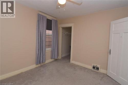 Unfurnished bedroom with carpet, a ceiling fan, and a walk in closet - 82 Somerset Avenue, Hamilton, ON - Indoor Photo Showing Other Room
