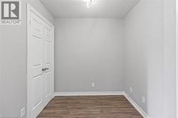 Unfurnished bedroom with a textured ceiling and dark wood finished floors - 