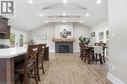 Dining area featuring light wood-style floors, french doors, and a premium fireplace - 