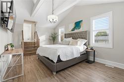 Bedroom with light wood-style flooring and a chandelier - 