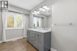Bathroom featuring double vanity and light wood-style flooring - 