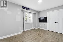 Unfurnished bedroom featuring light wood-style floors and a closet - 