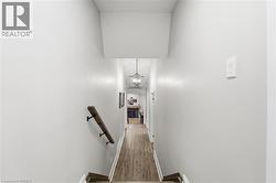 Staircase featuring wood finished floors, a towering ceiling, and a chandelier - 