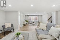 Living area with recessed lighting, wood finished floors, and stairway - 