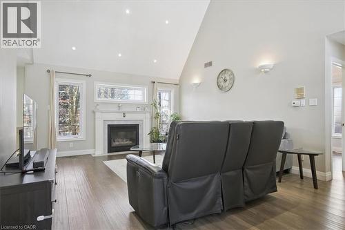 Living room with high vaulted ceiling, a fireplace with flush hearth, and wood finished floors - 629 Burning Bush Road, Waterloo, ON - Indoor Photo Showing Living Room With Fireplace