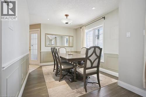 Dining space with wood finished floors, wainscoting, a textured ceiling, and a decorative wall - 629 Burning Bush Road, Waterloo, ON - Indoor Photo Showing Dining Room