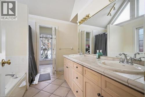 Bathroom featuring lofted ceiling, double vanity, light tile patterned floors, a bath, and curtained shower - 629 Burning Bush Road, Waterloo, ON - Indoor Photo Showing Bathroom