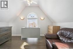 Bedroom featuring dark wood finished floors, lofted ceiling, and a ceiling fan - 