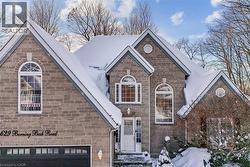 View of front facade featuring stone siding and a garage - 