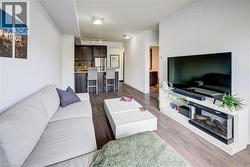 Living room with dark wood-style floors and rail lighting - 