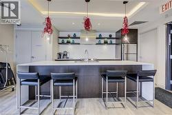 Kitchen with open shelves, freestanding refrigerator, a spacious island, pendant lighting, and a breakfast bar area - 