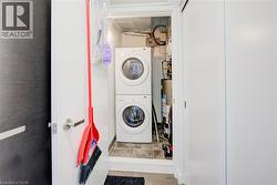 Washroom with stacked washer and clothes dryer and gas water heater - 