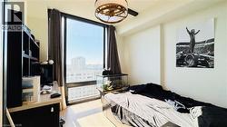 Bedroom with light wood-type flooring and a city view - 