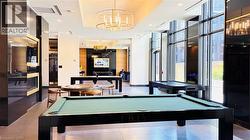 Rec room featuring pool table, a wall of windows, a chandelier, and recessed lighting - 