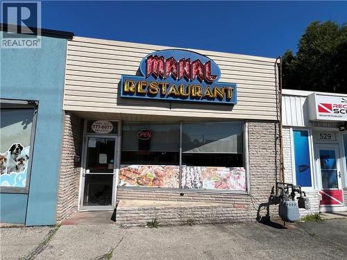 Commercial storefront featuring a large display window, prominent signage, and a glass entry door - 527 Upper Sherman Avenue, Hamilton, ON 