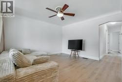 Living area featuring light wood-style flooring and ceiling fan - 