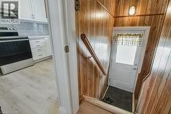 Entryway with light wood finished floors and wooden walls - 