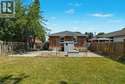 Rear view of house with a patio area, brick siding, and a fenced backyard - 