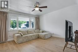 Living room with wood finished floors and a ceiling fan - 