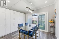 Dining room featuring dark wood-type flooring, ornamental molding, vaulted ceiling, and recessed lighting - 