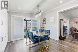 Dining room featuring dark wood-style floors, crown molding, recessed lighting, and lofted ceiling - 
