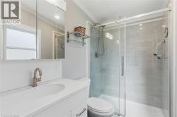 Bathroom with vanity, a shower stall, and ornamental molding - 