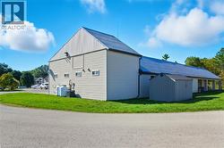 View of home's exterior featuring a lawn and an outdoor structure - 