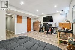 Bedroom with light wood-style floors, an office area, and recessed lighting - 