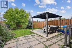 Fenced backyard featuring a gazebo, an outdoor hangout area, and a patio - 