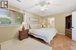 Tiled bedroom with connected bathroom and a ceiling fan - 