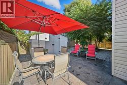 Fenced backyard featuring outdoor dining area, a patio area, and a storage shed - 
