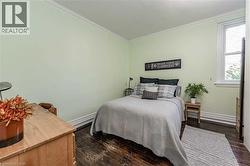 Bedroom with dark wood-style floors and ornamental molding - 