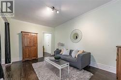 Living area with dark wood-style floors and ornamental molding - 