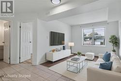 Living area featuring light tile patterned flooring and baseboards - 