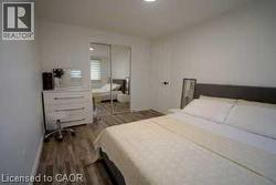 Bedroom with a closet and dark wood finished floors - 