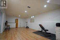 Workout room with light wood-style flooring and recessed lighting - 