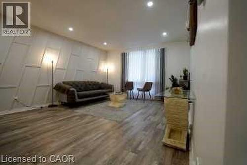 Living area with a decorative wall, recessed lighting, and wood finished floors - 147 Muriel Crescent, London, ON - Indoor