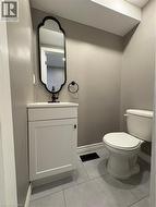 Half bathroom with vanity and light tile patterned flooring - 